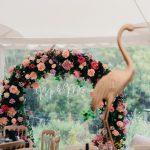 Wedding decorations including a floral ring and flamingo statue